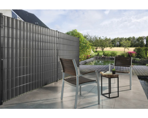 Scenă de grădină cu paravan de intimitate, scaune și iaz