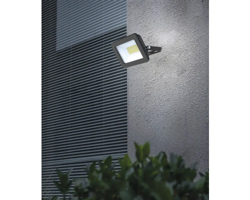 Reflector LED exterior pătrat montat pe un perete de casă.