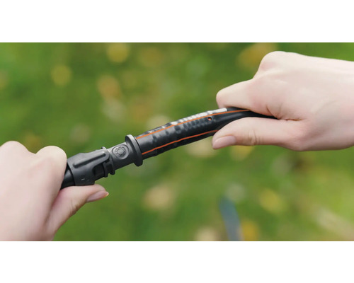 Două mâini conectează un furtun de grădină la un conector.