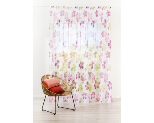 Șaluri decorative cu model floral în fața ferestrei și fotoliu de ratan cu perne