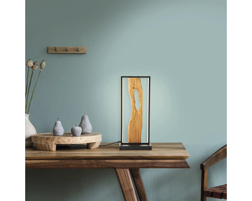 Lampă decorativă de masă din lemn și rășină sintetică pe o masă din lemn