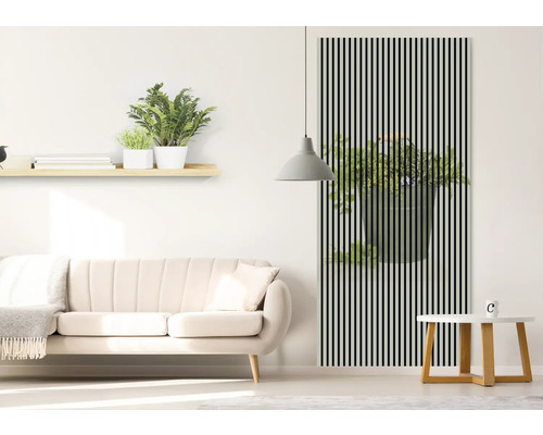 Living cu canapea, masă și decor de perete cu motiv de plante în spatele dungilor negre