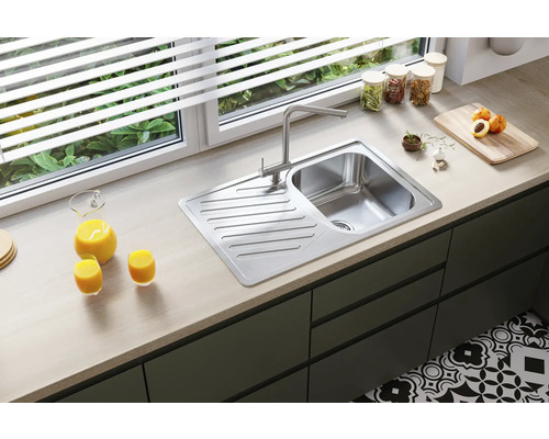 Chiuvetă din oțel inoxidabil cu picurător și baterie monocomandă într-o bucătărie modernă.