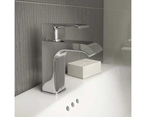 Baterie de lavoar lucioasă din metal pe o chiuvetă