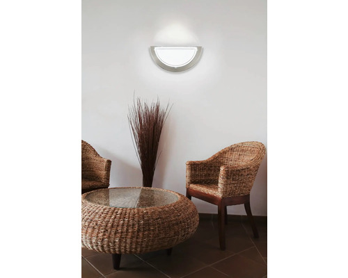 Lampa de perete semicirculară deasupra unei zone de relaxare cu mobilier din răchită