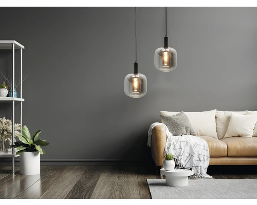 Cameră de zi cu două lămpi suspendate, canapea și raft