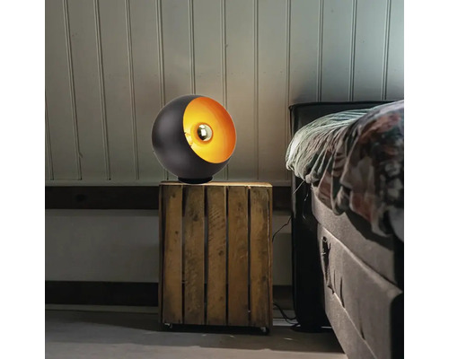 Lampă sferică neagră cu interior metalic pe o noptieră