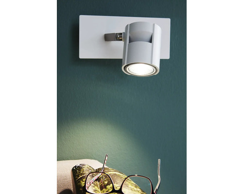 Spot de perete pentru iluminarea unui spațiu de locuit cu ochelari în prim plan