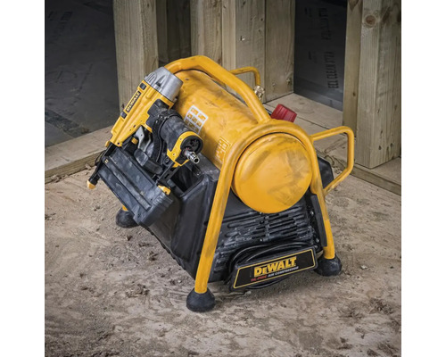 Compresor de aer galben DeWalt cu capsator pneumatic pe un șantier de construcții
