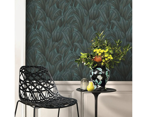 Tapetă decorativă cu model de frunze, masă cu aranjament floral și scaun de design