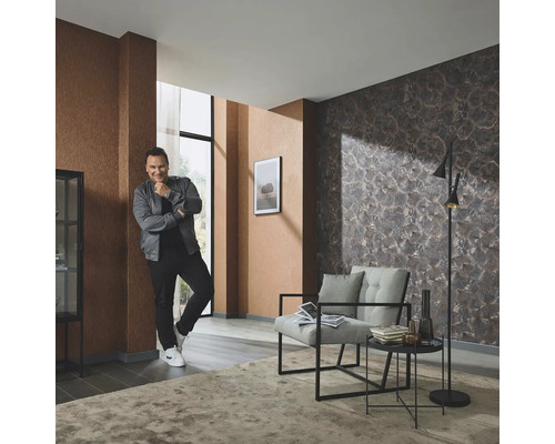 Cameră de zi cu tapet cu model, fotoliu, lampă de podea și covor