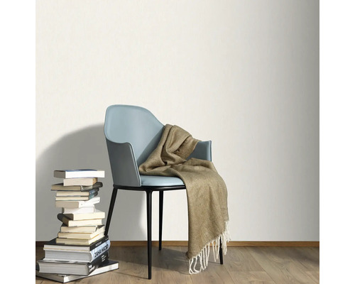 Cameră luminoasă cu stivă de cărți, scaun și pătură