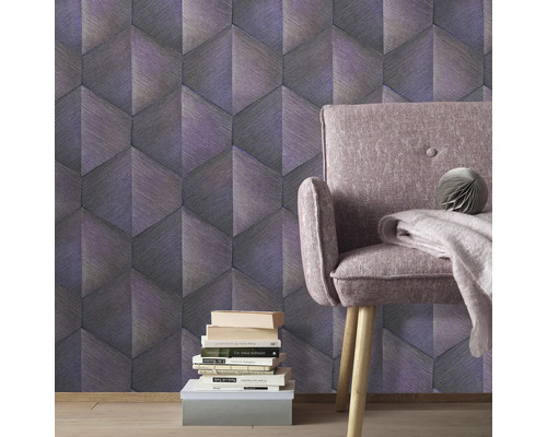 Vedere a camerei cu tapet grafic, fotoliu și stivă de cărți.