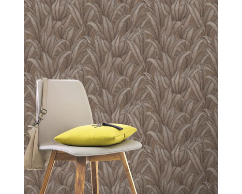 Perete cu tapet cu model de frunze, scaun cu pernă și geantă