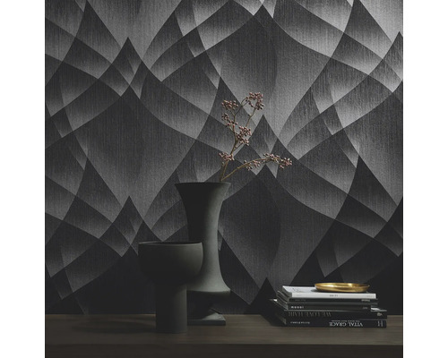 Fotografie de interior a unei camere cu tapet cu model, cărți și vaze pe o masă.