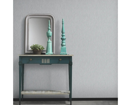 Interior decorativ cu masă, oglindă și ornamente în fața unui perete cu tapet