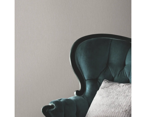 Prim-plan cu tapet texturat cu un fotoliu în fundal.