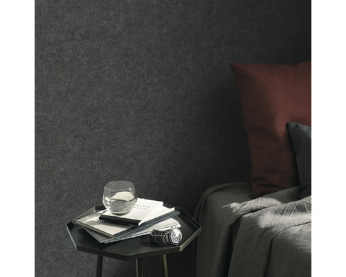 Scenă de living cu tapet textil, noptieră, caiete, pahar cu apă și ceas de mână