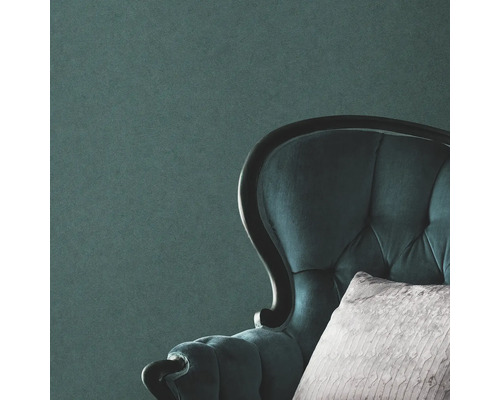 Prim-plan al unui fotoliu tapițat cu pernă în fața unui perete