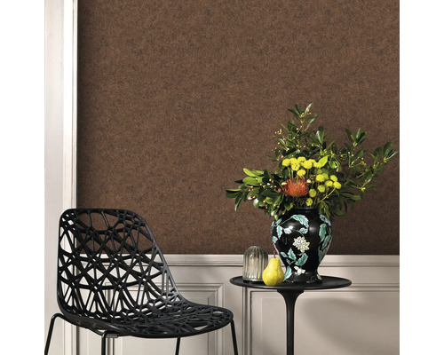 Cameră de zi cu tapet maro, scaun și aranjament floral pe o masă