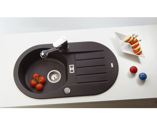 Chiuvetă de bucătărie cu robinet și zonă de scurgere pe un blat de lucru