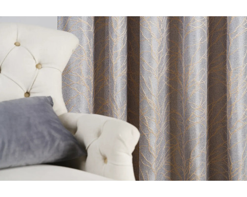 Cortină decorativă gri cu model de frunze lângă un fotoliu