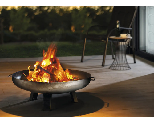 Vatră cu lemne arzând pe o terasă cu locuri de ședere
