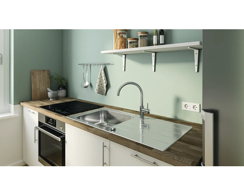 Scenă de bucătărie cu chiuvetă, plită și ustensile de bucătărie pe perete