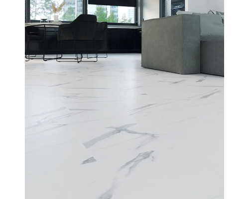 Cameră de zi luminoasă cu gresie cu aspect de marmură, zonă de bucătărie și canapea gri