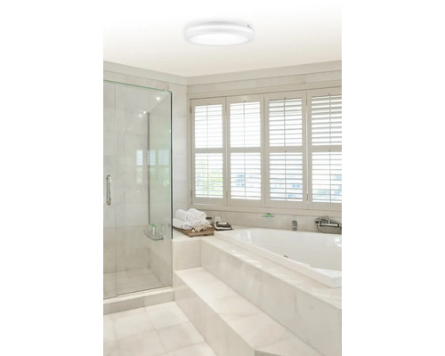 Baie modernă cu cabină de duș, cadă și lampă rotundă de tavan.