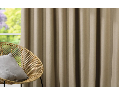 Cortină decorativă lângă un scaun de ratan în fața unei ferestre