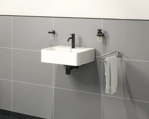 Lavoar suspendat cu robinet, dispenser de săpun, suport pentru periuțe de dinți și suport pentru prosoape pe un perete