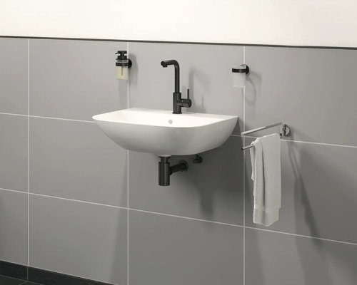 Baie modernă cu chiuvetă, robinet, dozator de săpun, pahar pentru periuțe de dinți și suport pentru prosoape