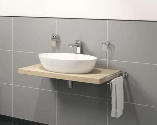 Chiuvetă pe placă de lemn cu robinet, dozator de săpun, suport pentru periuțe de dinți și suport pentru prosoape în fața unui perete gri