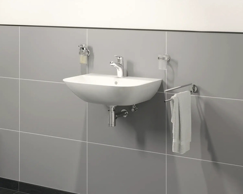 Chiuvetă ceramică cu robinet, dozator de săpun, suport pentru periuțe de dinți și suport pentru prosoape pe un perete gri