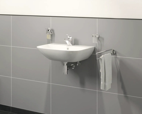 Chiuvetă cu robinet, dozator de săpun și suport pentru prosoape pe un perete placat cu faianță