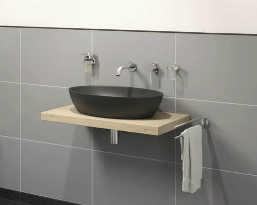 Baie modernă cu lavoar negru așezat pe dulap inferior din lemn deschis la culoare, baterie și suport pentru prosop