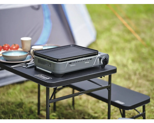Masa de camping cu aragaz pe gaz, veselă și alimente în aer liber