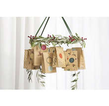 Calendar de Advent suspendat cu pungi de hârtie pe o coroană