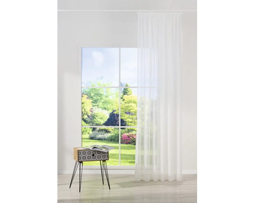 Cameră luminoasă cu fereastră, perdea albă și măsuță laterală