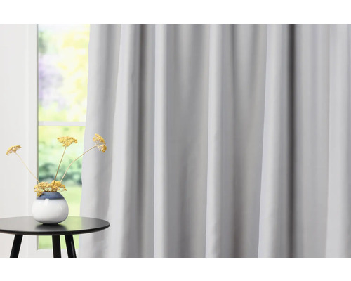 Cortină gri în fața ferestrei cu măsuță laterală și decorațiuni