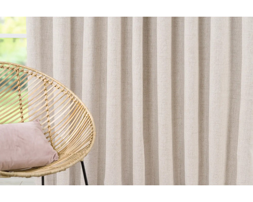 Atmosferă decorativă de locuit cu perdea, fotoliu și pernă.