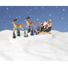 Moș Crăciun cu sania trasă de reni și brazi luminoși pe suprafață înzăpezită