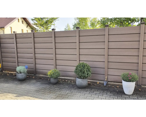 Vedere grădină cu gard maro de intimitate și jardiniere