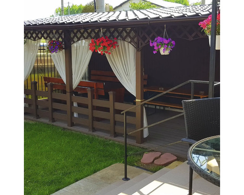 Foișor de grădină acoperit cu bănci, masă și perdele decorative.
