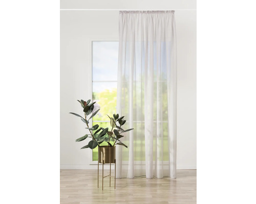 Living luminos cu fereastră, perdea și plantă de apartament în ghiveci.