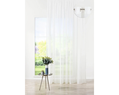 Perdea albă cu ochiuri în fața unei ferestre cu vedere la grădină