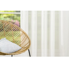 Living decorativ cu fotoliu din ratan și perdea transparentă