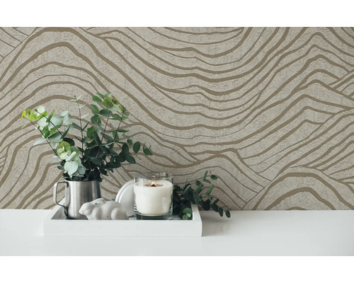 Tapet decorativ cu model ondulat ca fundal pentru un aranjament cu lumânare și plante.