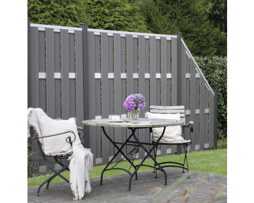 Grădină cu gard din lemn și zonă de relaxare cu masă și scaune